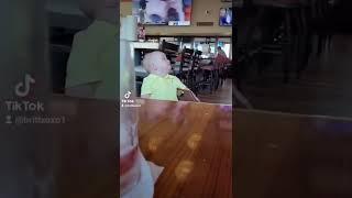 Toddler stares at the waitress in Hooters restaurant 