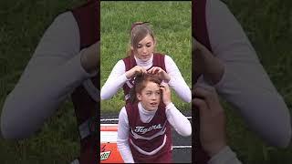 Our cheer team fixing her hair at our football game.