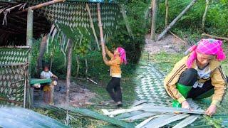 Mother and daughter used forest leaves to weave a leaf fence to repair their small hut.