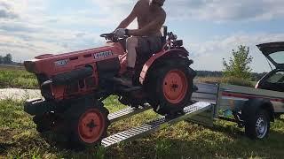 Compact tractor Kubota B6001 driving to trailer for transportation
