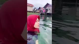 jilbab merah mandi di laut pagi hari