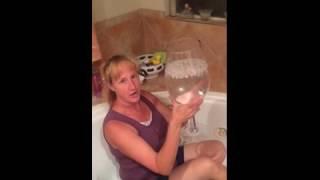A woman dumps a giant wine glass of water over her head i...