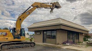 Caterpillar excavator crushes entire retail building