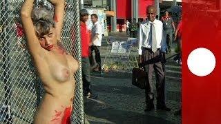 Chained naked to a fence woman protests against sexism in Brazil