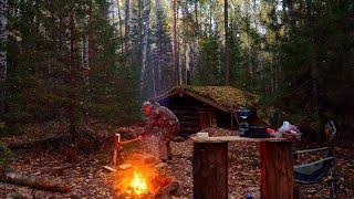 Building a dugout for winter survival. Warm underground shelter in the wild forest