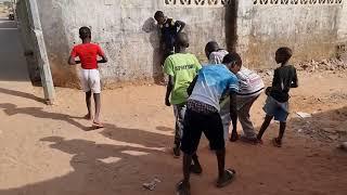 The Gambia - Bakau  Cape Point a suburb of Banjul - boys playing marbles. Similar to Afghan kids