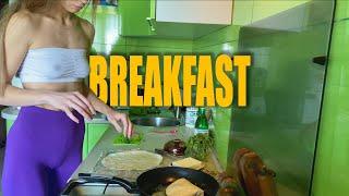 Girl cooking breakfast in leggings and white top