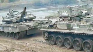 Captured A Russian T-80BV battle tank is towed by a Ukraine BREM-1 across a pontoon bridge