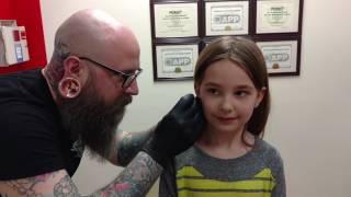 Seven year old gets her ears pierced needle method