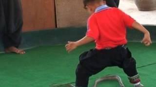 Boy jumping over snake during performance in Thailand