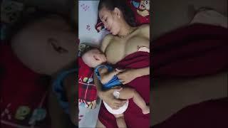 ibu menyusui bayi sambil meniduri 