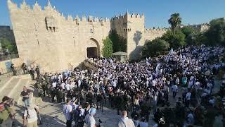Participants in the Jerusalem Day Flag March walk through the Damascus Gate into the Muslim Quarter
