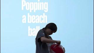 Popping a beach ball but there’s a twist