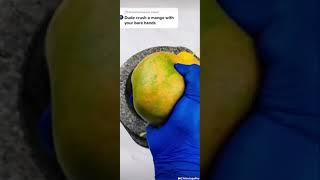crushing mango with hand 