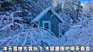 森林木屋独居，外面大雪纷飞，一个人在火炉旁喝茶看雪