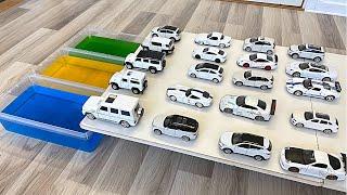 Various White Diecast Model Cars Sliding Into The Green Blue And Yellow Water