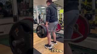 Man does 8x5 trap bar dead another man looks on nestled away in the leg press