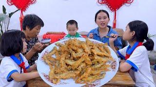 Dad uses a hammer to hit the fish to make a plate of fried fish