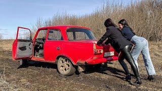 CAR STUCK  Two girls in a car stuck in the mud. Mud high heels and dirty sock.