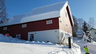 Using rope to remove snow from a roof.