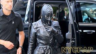 Kim Kardashian checks into her hotel wearing a leather face mask