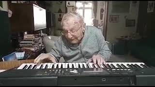 A 100 years old grandpa singing and playing his piano
