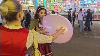 Girls have fun blowing up balloons too big in public Preview Clip