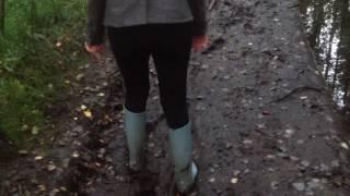 Girl walking in mud in Wellington boots