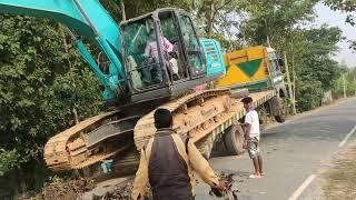 Excavator Kobelco unloading from tronton