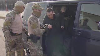 Jailed American Marine veteran Trevor Reed is escorted to an airport in Moscow