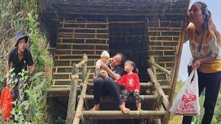 Single mother calms down her 3-month-old child. Completed bamboo house