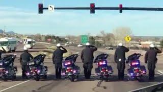 Police officers salute soldiers returning home from Afghanistan