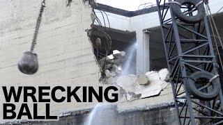 Wrecking ball in action demolishing a concrete building