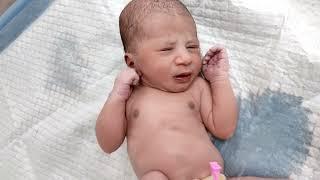 Beautiful Newborn baby after birth born via normal Delivery Process pee on examination table