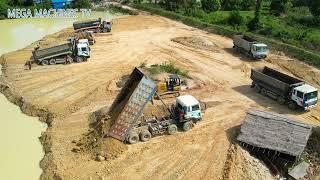 Huge land filling up Bulldozer moving dirt huge dump truck unloading dirt