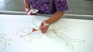 Wax drawing with a canting in Batik drawing process