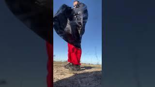 Red white jumpsuit with a test cape blowing in the wind