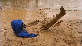 Rubber boots and wader suit in mud