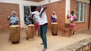 Rwandan women drumming and man dancing