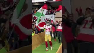 Fred Warner leads the 49ers onto the field with the Mexican national flag 