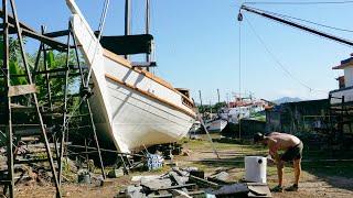 Installing a restored muffler to the exhaust system of our once wrecked boat — Sailing Yabá 193